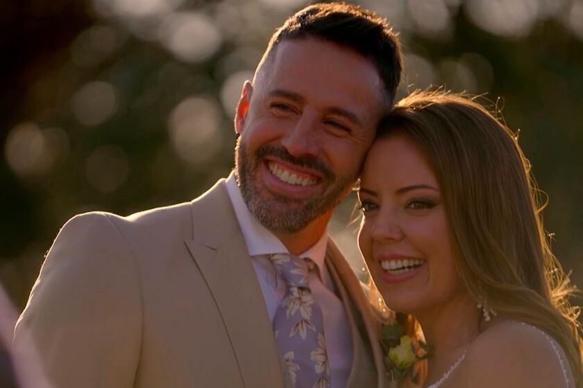 Pareja recién casada en 'Casados a primera vista' con anillos y sonrisas nerviosas, fondo de estudio con luces cálidas