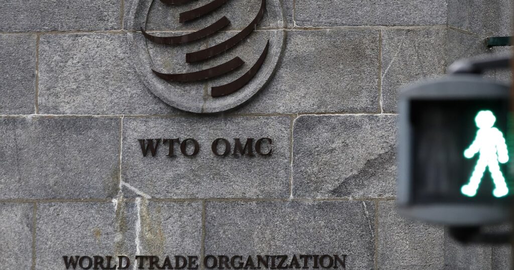 Mapamundi con flujos de datos globales y símbolos de dólares sobre pantalla digital con logo de la OMC