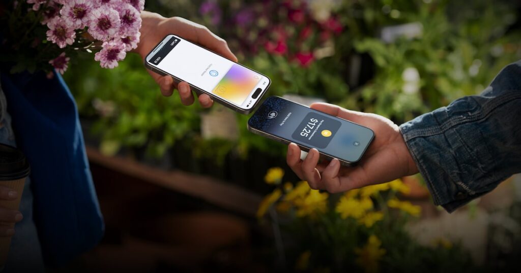 Persona pagando con tarjeta contactless en un iPhone usando Tap to Pay en un mercado mexicano