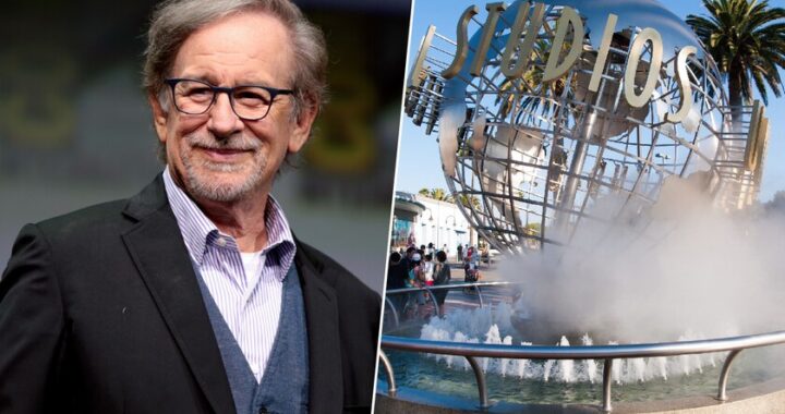 Steven Spielberg sonríe junto a un contrato firmado en 1987 con Universal Studios sobre una mesa con billetes y un plano de parque temático