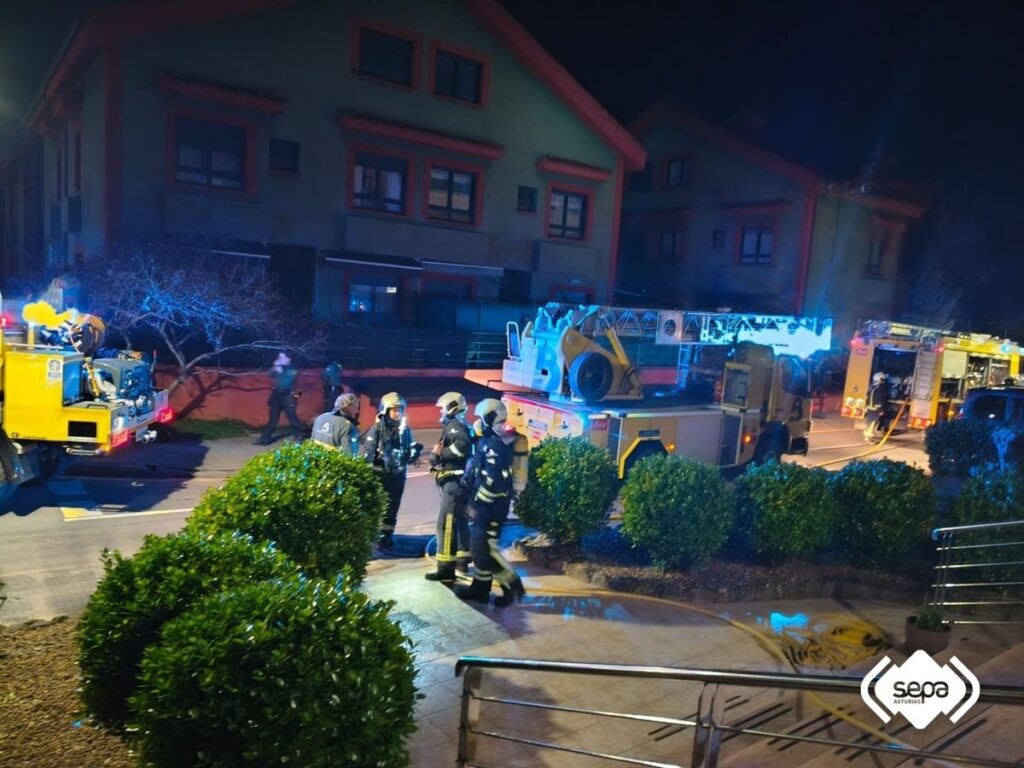 Bomberos con mangueras apagan incendio nocturno en hotel de Arriondas mientras huéspedes evacúan en pijama