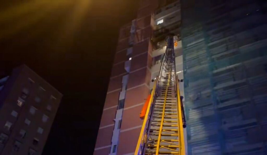 Bomberos rescatando a una anciana de 80 años desde el balcón de un piso en llamas en planta 9ª