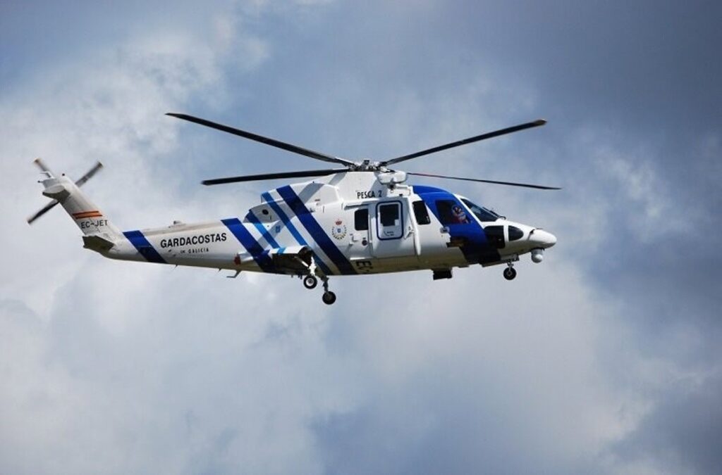 Helicóptero Pesca II izando a un motorista herido en acantilados de Pedra do Sal con equipo de rescate en rápel