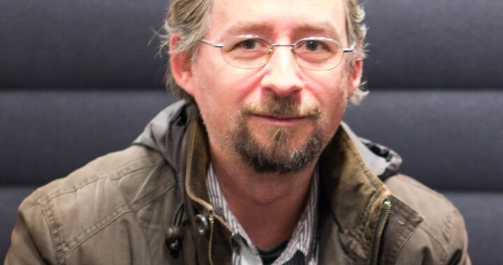 Retrato de Adam Back con código de Hashcash y Bitcoin superpuesto, simbolizando el vínculo técnico con Satoshi Nakamoto