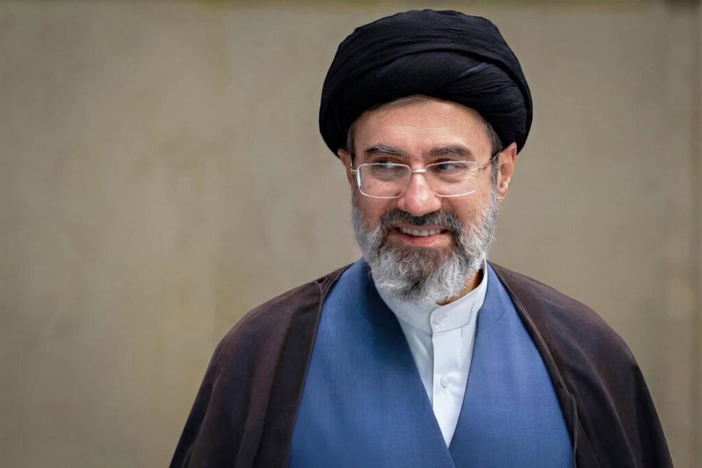 Ayatolá Jamenei en discurso con mapa del golfo Pérsico y bandera iraní al fondo, señalando 'EEUU al fondo del mar'