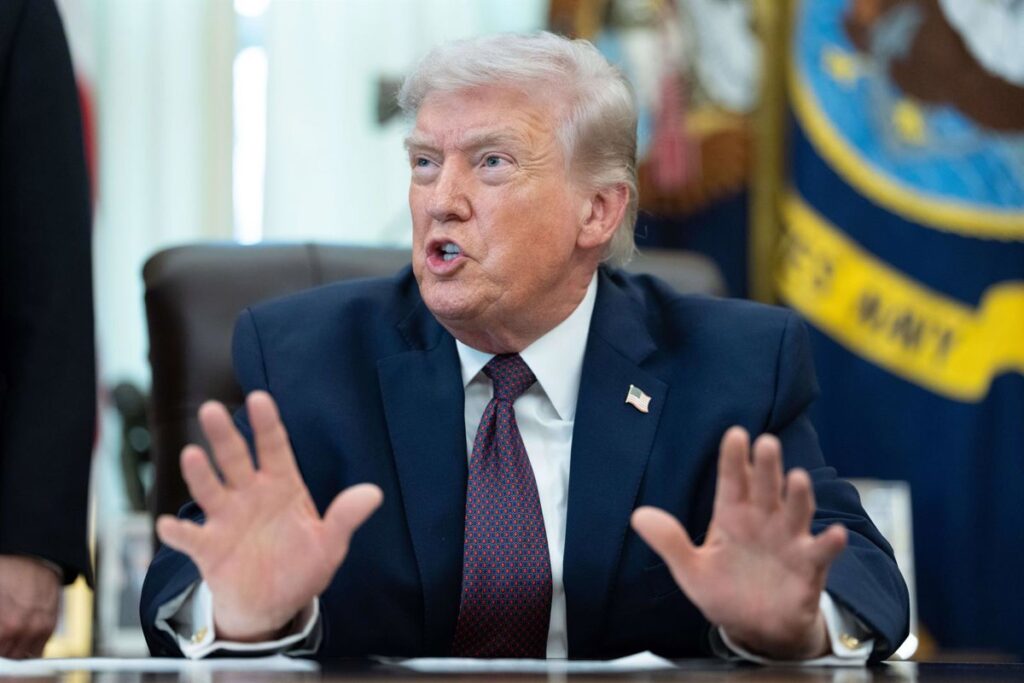 Donald Trump en rueda de prensa anunciando posible salida de EE.UU. de la OTAN con mapa de Europa al fondo