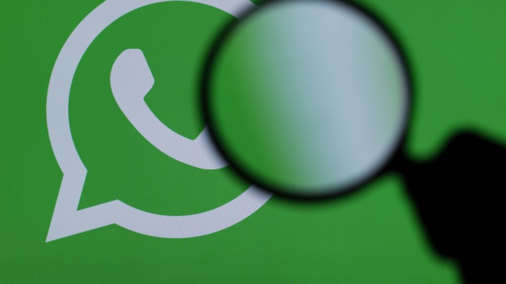 Pantalla de smartphone mostrando alerta de seguridad por app falsa de WhatsApp con logo de spyware superpuesto