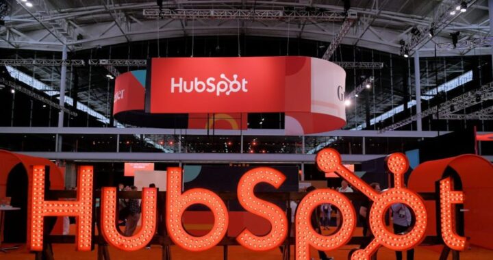 Oficina moderna en São Paulo con logos de HubSpot, IA y WhatsApp en pantallas futuristas