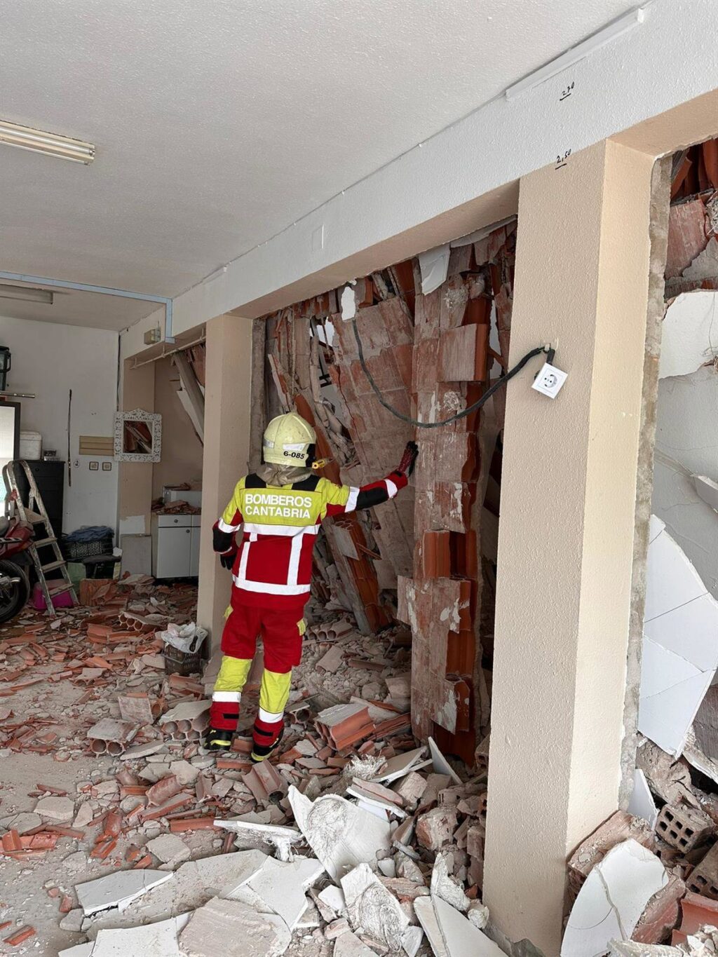 Edificio en Los Corrales de Buelna con techo derrumbado durante reformas y bomberos evacuando vecinos