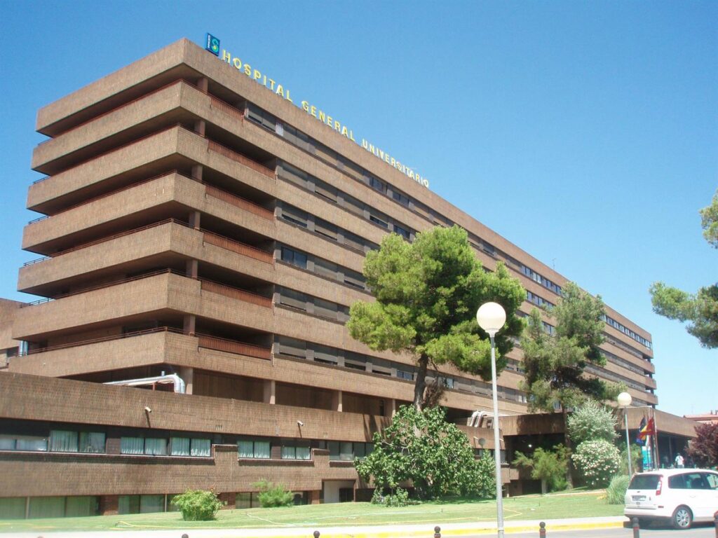 Trabajador herido junto a neumático reventado en taller mecánico con equipos de emergencia