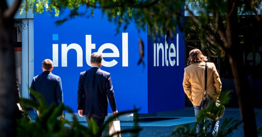 Lip-Bu Tan, CEO de Intel, en reunión estratégica con gráficos de producción de chips 20A y logos de Tesla y Apple al fondo