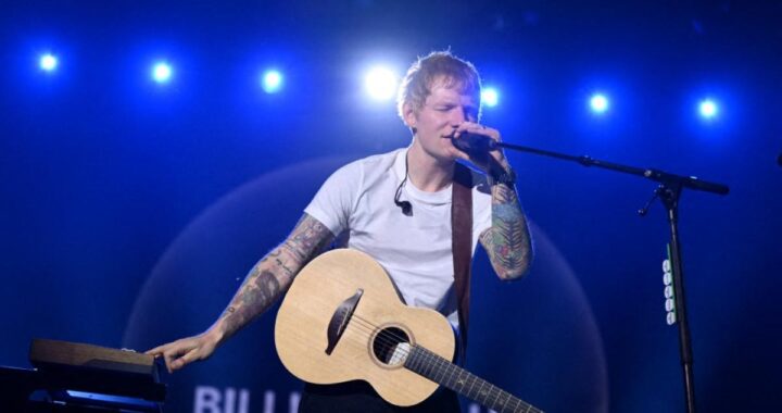 Ed Sheeran en el escenario del Mathematics Tour 2025 con multitudes en un estadio lleno de luces y energía