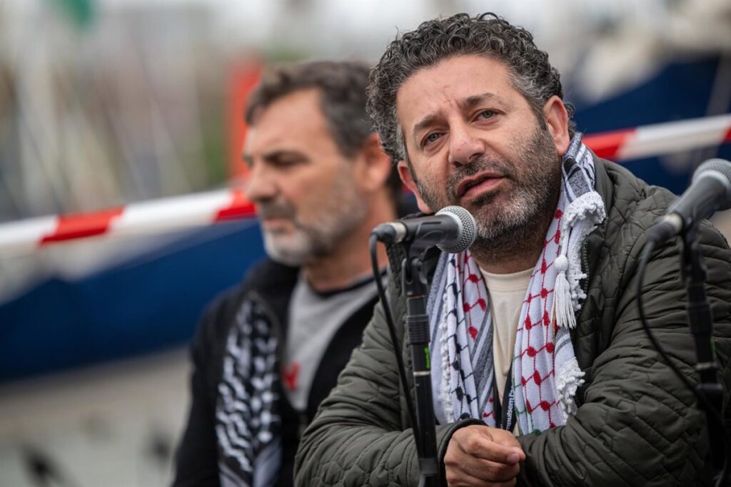 Saif Abukeshek con puño en alto al llegar a Atenas tras su liberación por Israel, simbolizando la lucha por Palestina libre
