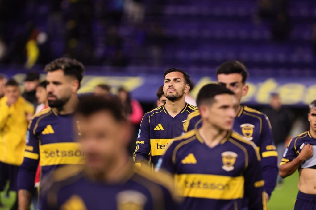 Jugadores de Boca abatidos tras derrota 3-2 en la Bombonera, con Huracán celebrando en el fondo