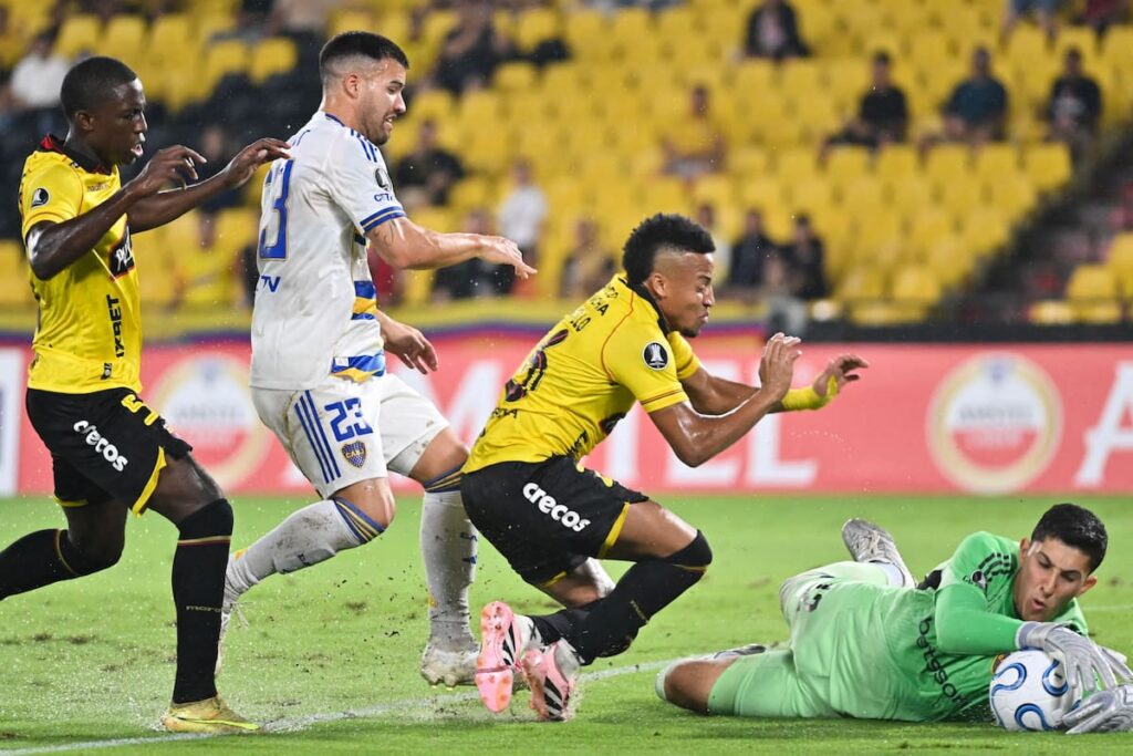 Jugadores de Boca abatidos en el lodazal de Guayaquil tras gol de Barcelona EC, con arquero en camilla al fondo