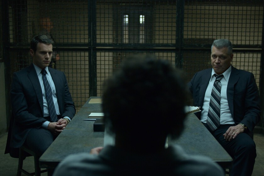 Agentes del FBI entrevistando a un asesino en serie en escena de 'Mindhunter' con estilo visual frío y realista