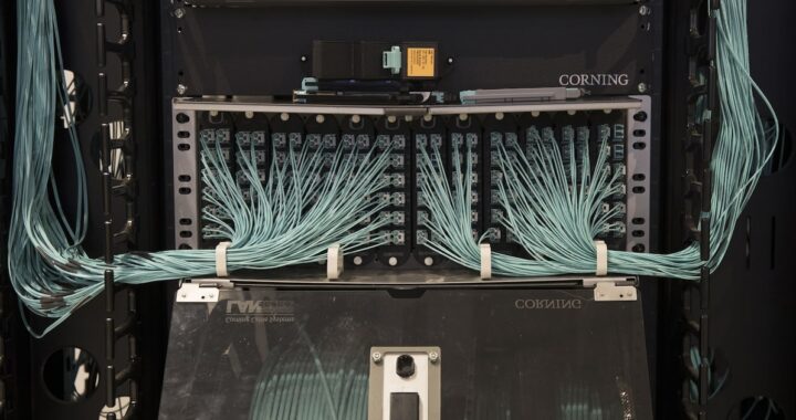 Gráfico de acciones de Corning con alza del 12,01% junto a logo de Nvidia y fibra óptica brillante