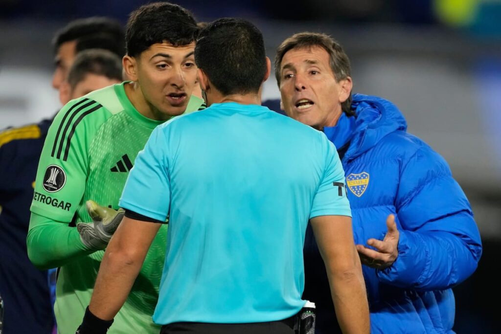 Árbitro revisa jugada polémica de mano en partido de fútbol con VAR, mostrando confusión en las reglas