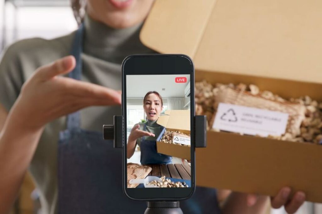 Influencer mostrando producto en transmisión en vivo con botón de compra activo y chat interactivo