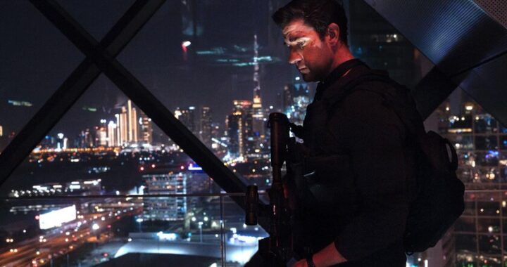 John Krasinski como Jack Ryan en escena de acción de la película 'Guerra encubierta' con fondo de Praga iluminada