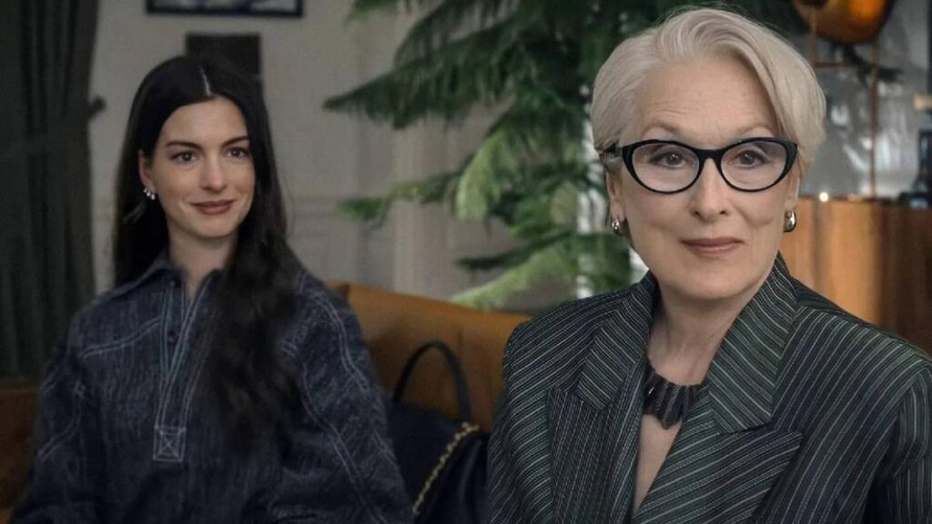 Meryl Streep como Miranda Priestly en cartel de 'El Diablo Viste a la Moda 2' con fondo de revistas y luces de Broadway