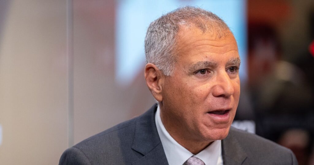 Ejecutivo de HSBC en Hong Kong anunciando recortes laborales por implementación de IA en gráficos financieros con datos de empleo