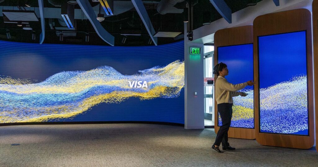 Ejecutivo usando smartphone para pagar a proveedores con credenciales virtuales de Visa en Brasil