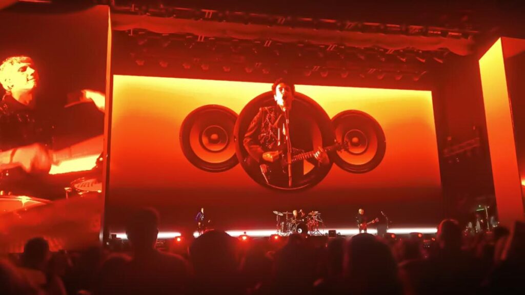Holograma hiperrealista de Gustavo Cerati en escenario con Charly Alberti y Zeta Bosio durante concierto en Quito 2026
