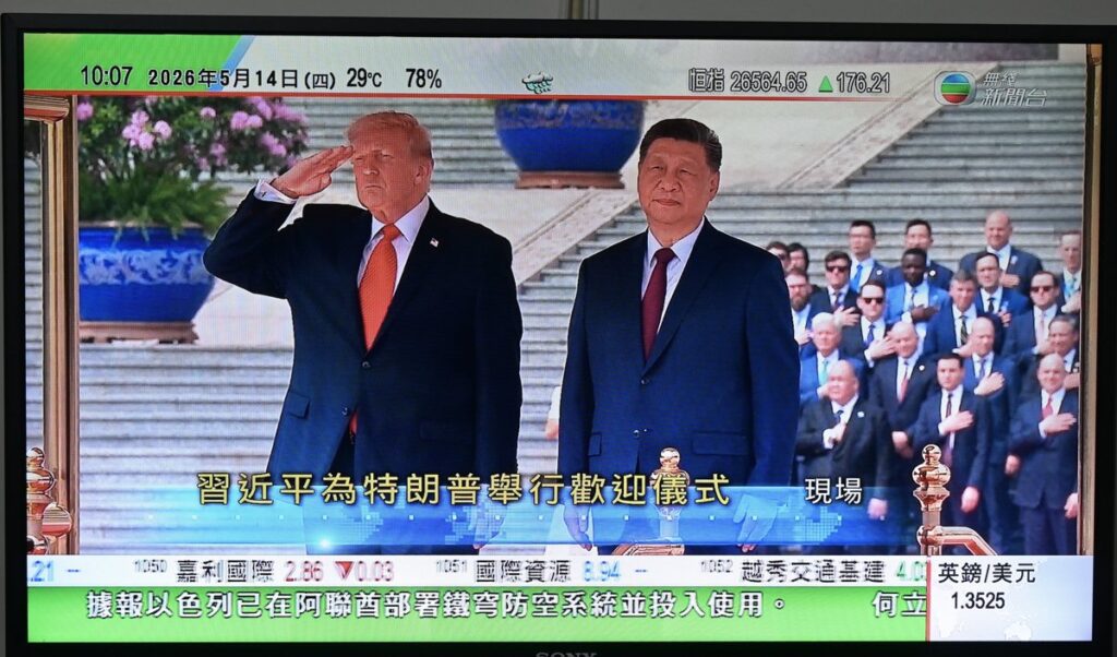 Donald Trump con Tim Cook y Elon Musk en reunión con empresarios chinos en Pekín, con banderas de EE.UU. y China de fondo