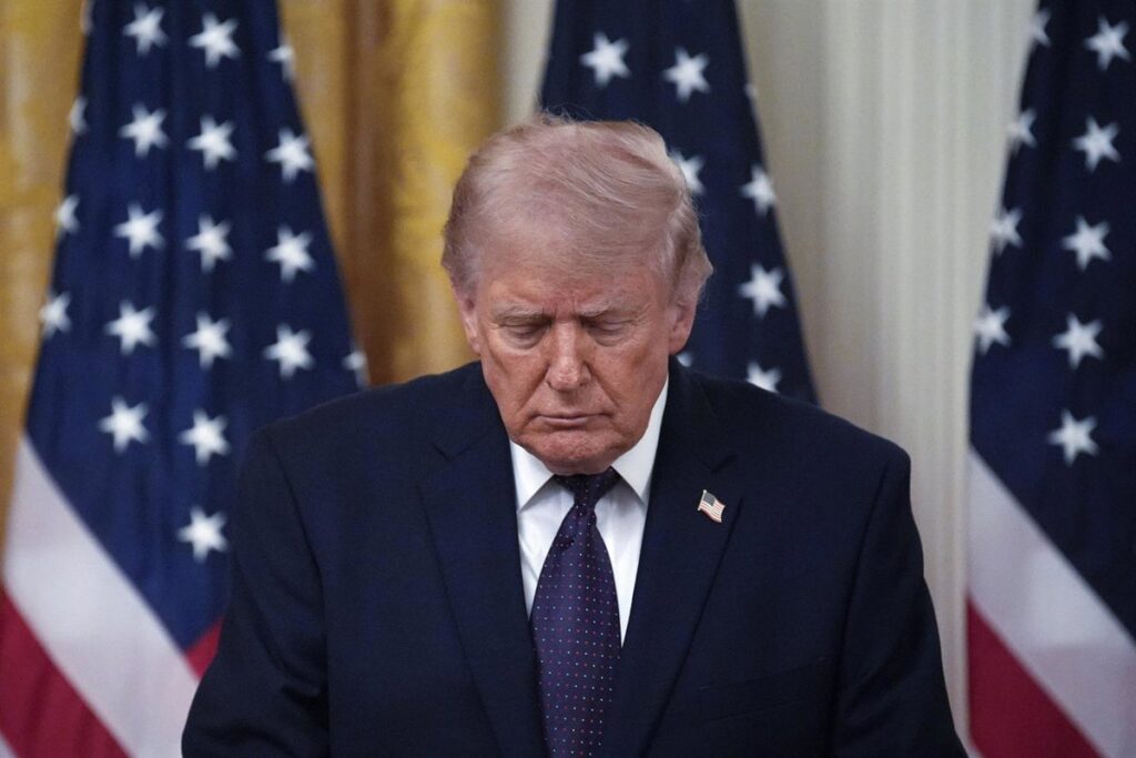 Donald Trump en discurso con bandera de EE.UU. mientras exige condiciones duras a Irán en negociaciones nucleares