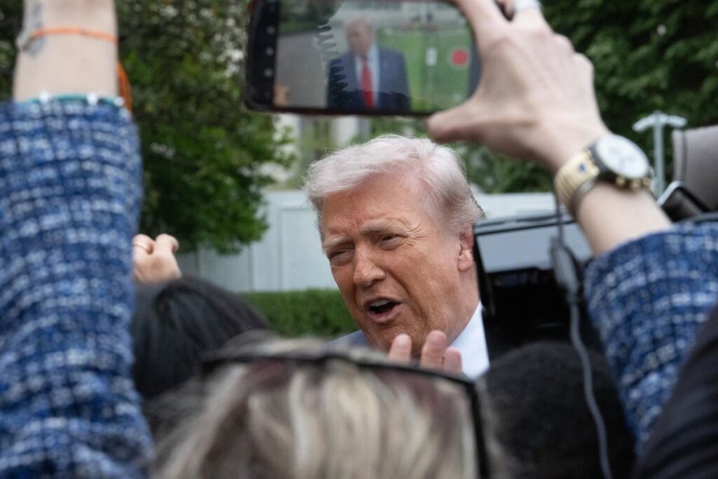 Donald Trump con expresión seria frente a bandera de EE.UU. tras rechazar acuerdo nuclear con Irán y uranio enriquecido al 60%