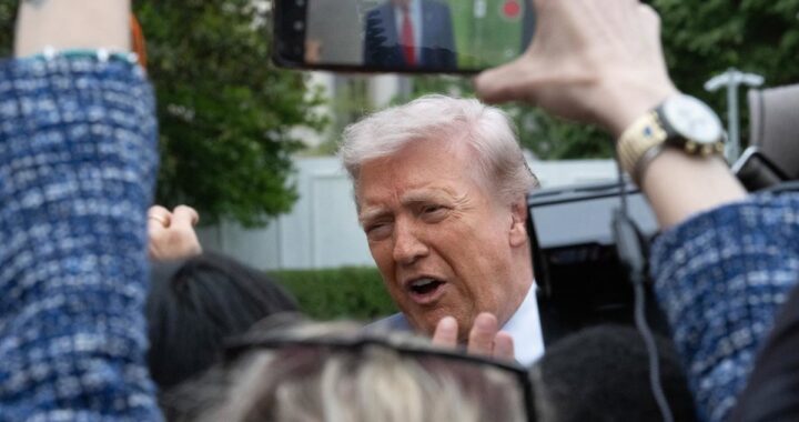 Donald Trump con expresión seria frente a bandera de EE.UU. tras rechazar acuerdo nuclear con Irán y uranio enriquecido al 60%