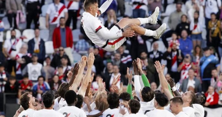 Óscar Trejo, capitán del Rayo Vallecano, levanta los brazos en Vallecas con el estadio de fondo y hinchas emocionados