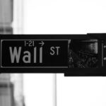 Gráfico comparativo de Wall Street en caída y IBEX 35 en alza con datos de Nasdaq, S&P 500 y Dow Jones