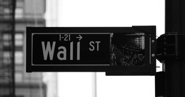 Gráfico comparativo de Wall Street en caída y IBEX 35 en alza con datos de Nasdaq, S&P 500 y Dow Jones