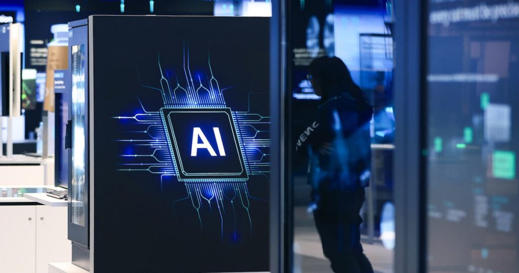 Ejecutivo de banco analiza datos mientras pantalla muestra algoritmo de IA reemplazando tareas de analistas junior