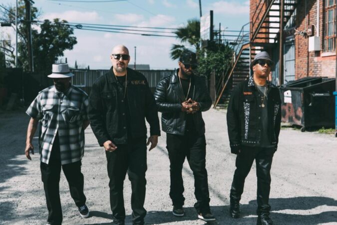 Cypress Hill en foto oficial de gira 2026 con fondo de escenario y luces de concierto
