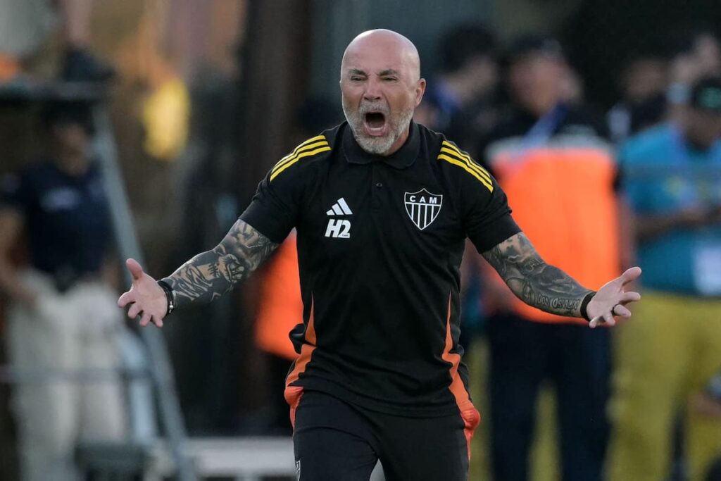 Jorge Sampaoli en rueda de prensa como nuevo DT de Talleres de Córdoba, sonriendo con camiseta del club