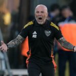 Jorge Sampaoli en rueda de prensa como nuevo DT de Talleres de Córdoba, sonriendo con camiseta del club