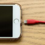 Celular conectado a cargador con advertencia de batería dañada por voltaje inestable y malos hábitos