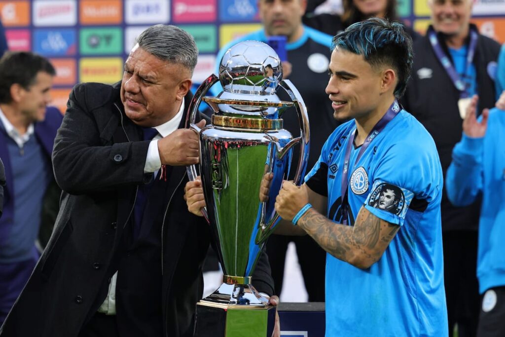 Mapa mundial con 15 banderas destacadas simbolizando los candidatos al título en el Mundial 2026 y trofeo en el centro