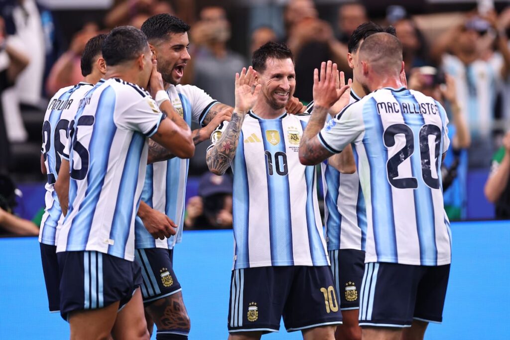 Jugadores de Argentina celebran su clasificación a 16avos de final con Scaloni y Messi en el banco