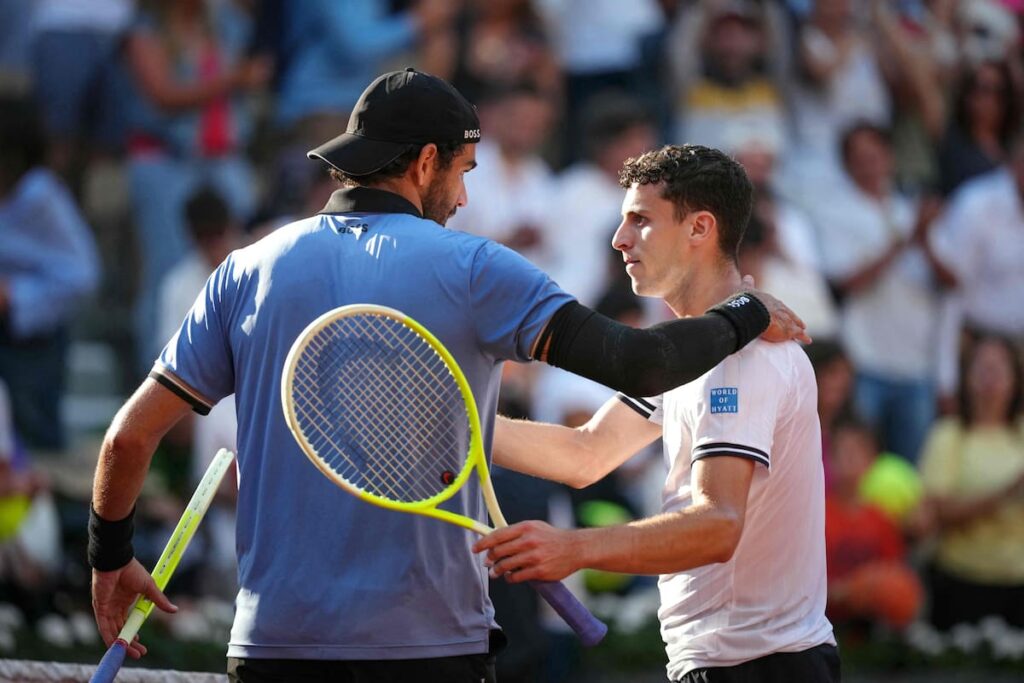 Juan Manuel Cerúndolo agacha la cabeza tras perder con Berrettini en octavos de Roland Garros 2025, con la arcilla roja de fondo
