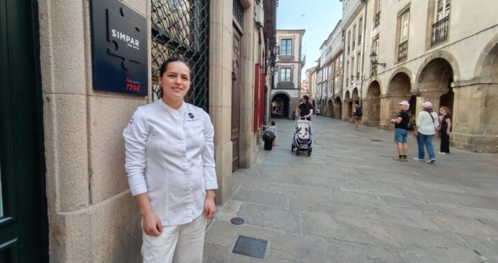 Claudia Merchán, chef ecuatoriana, sonríe en la cocina de Simpar con su delantal y la placa de estrella Michelin 2025