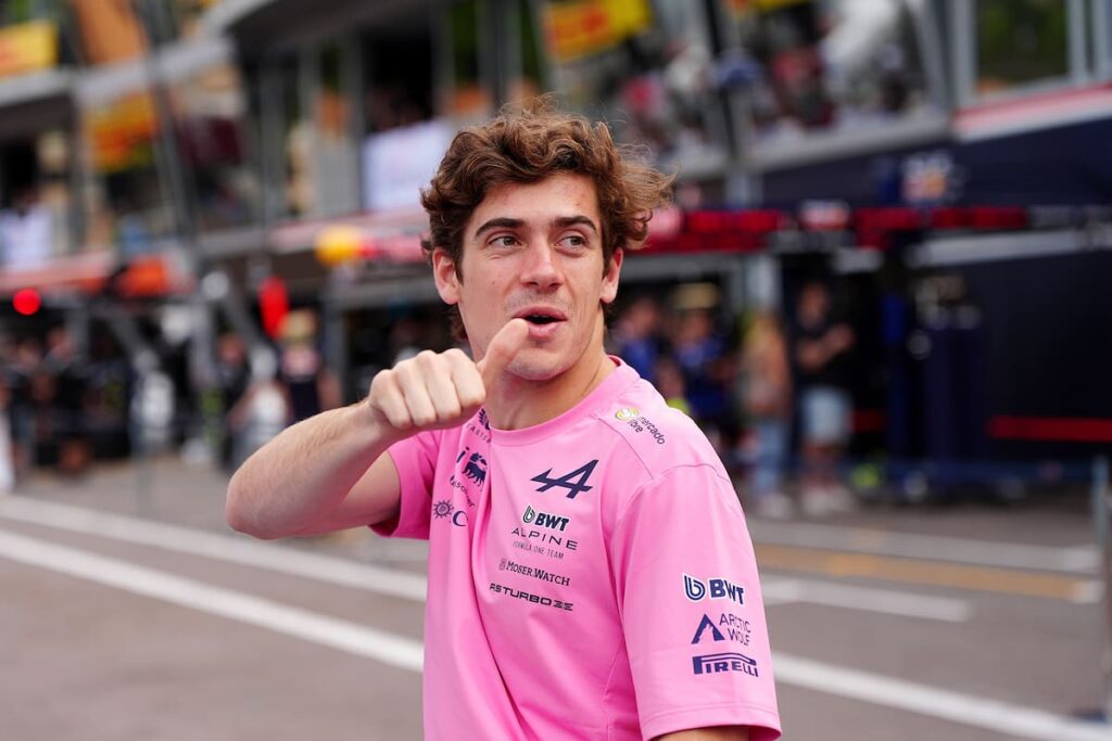 Franco Colapinto analizando datos técnicos en boxes con el circuito de Mónaco y yates de fondo, bajo presión por el nuevo reglamento eléctrico