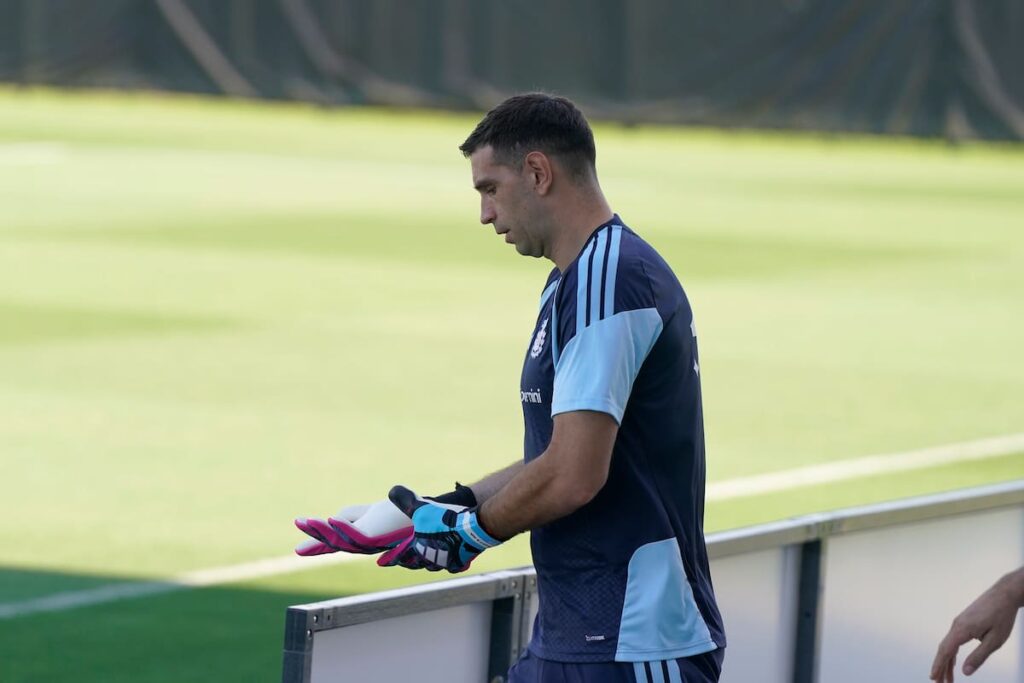 Emiliano Martínez entrenando con guantes y fractura en el dedo anular derecho en el césped