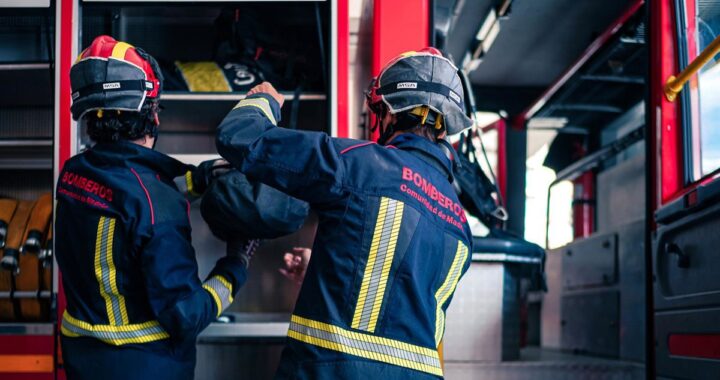 Bomberos trabajando de noche con mangueras para apagar incendio en arizónica de madera en Boadilla