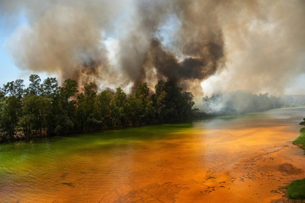 Equipos del Infoca trabajan en el incendio forestal de Villanueva de los Castillejos con autobombas y helicóptero
