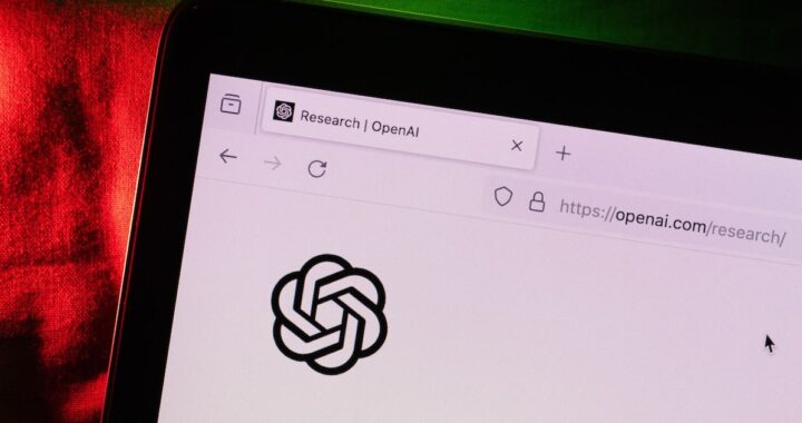 Logotipos de OpenAI y Anthropic en pantalla de teléfono móvil con fondo de bolsa de valores